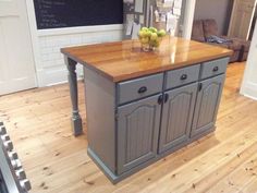 a kitchen island with some fruit in it on top of a hard wood flooring