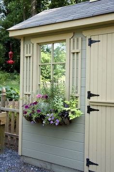 a window box with flowers in it next to a shed