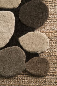 an area rug with several different colors and shapes on the carpet, including black, grey, white and beige circles