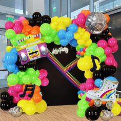 an arch made out of balloons and disco balls with a boombox in the middle