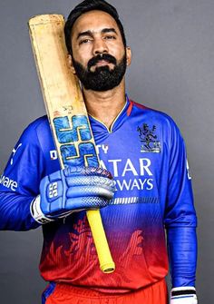 a man with a beard holding a cricket bat