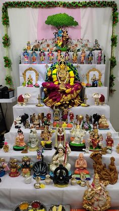 there are many figurines on the table and in front of it is a statue of lord ganeshh