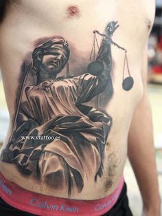 a man with a statue of liberty tattoo on his stomach and the scale of justice behind him