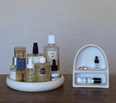 an assortment of beauty products sitting on a wooden counter top next to a soap dispenser