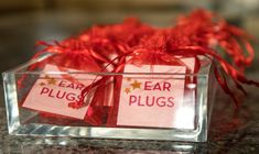 two clear boxes with red ribbon tied around them