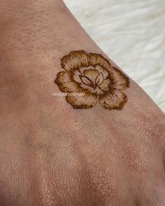 a hand with a flower tattoo on it