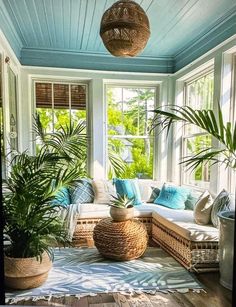 a living room filled with lots of furniture and large potted plants on the floor