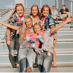 a group of women standing next to each other on top of a bleachers