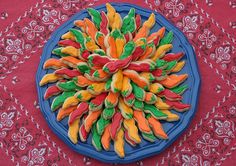 a blue plate topped with lots of colorful candy canes on top of a red table cloth