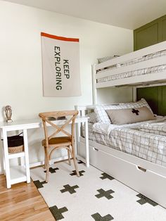 a bedroom with two bunk beds and a desk