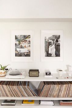 there are two pictures hanging on the wall above a shelf with record players and records