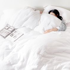 a woman laying in bed with her head on the pillow