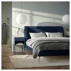 a bed with white pillows and blue headboard