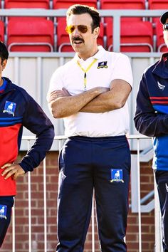 three men in uniforms standing next to each other with their arms crossed and looking at the camera