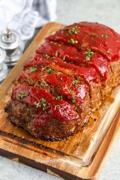 meatloaf with sauce and parsley on a cutting board