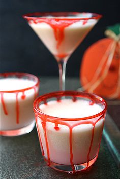 two glasses filled with liquid sitting on top of a table