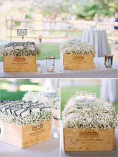 a wooden box filled with baby's breath flowers and candles on top of a table