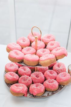 two tiered trays filled with pink donuts