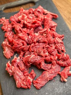 raw meat is on a cutting board with a knife next to it, ready to be cooked