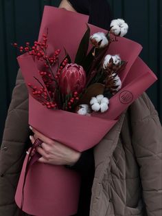 a woman holding a bouquet of flowers in her hands