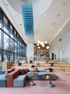 the interior of a modern office building with pink floors, blue and red couches