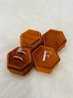 three orange velvet jewelry boxes with the letter f on them