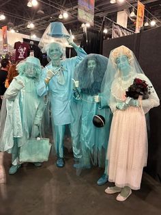 three people dressed in blue and white are standing next to each other at a convention