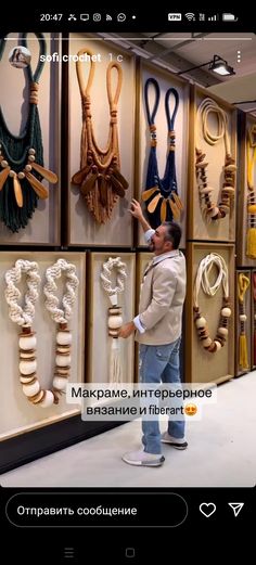 a man standing in front of a display of necklaces