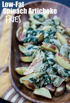 a wooden bowl filled with potatoes and spinach