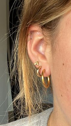 a woman wearing large gold hoop earrings