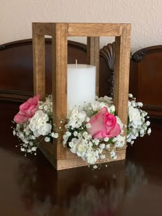 a wooden box with flowers and a candle