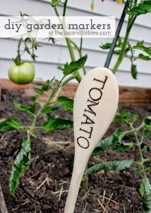 a wooden spoon with the words diy garden markers on it sitting in some dirt