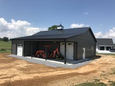 two tractors parked in front of a metal building