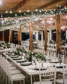 the tables are set with white linens and greenery for an outdoor wedding reception