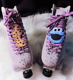 two purple shoes with sesame the cookie monster on them sitting on a white fur rug