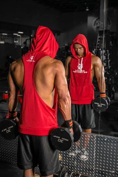 two men in red hoodies and black shorts holding dumbbells