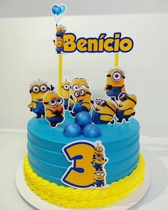 a blue and yellow birthday cake with minion decorations