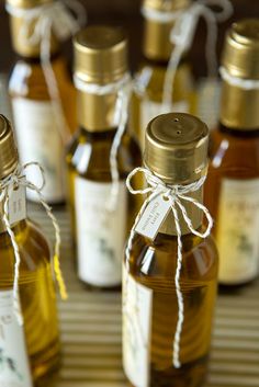 several small bottles filled with different types of liquid and tied with twine on a table