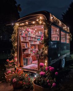 an old bus converted into a library with flowers and bookshelves