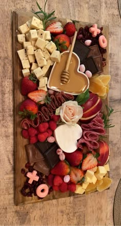 a wooden table topped with lots of different types of food and desserts on top of it