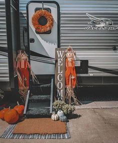 an rv with pumpkins and welcome sign