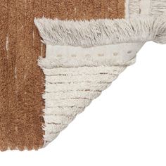 a brown and white rug with fringes on the bottom, in front of a white background