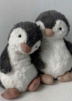 two stuffed penguins sitting next to each other