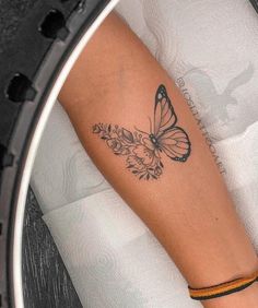 a woman's arm with a butterfly tattoo on it