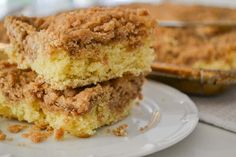 two pieces of cake sitting on top of a white plate next to a casserole dish