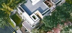 an aerial view of a house in the middle of some trees and bushes, looking down on it's roof