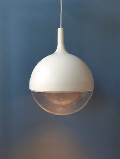 a white light hanging from a ceiling with a blue wall in the backround