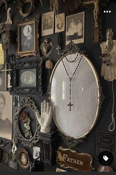 the wall is covered with many different pictures and framed objects, including an ornate cross