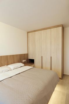 a large bed sitting next to a wooden cabinet in a bedroom on top of a hard wood floor