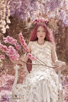 a woman sitting in a chair with pink flowers